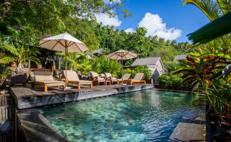 Sun loungers next to a tranquil pool, perfect for sunbathing or reading