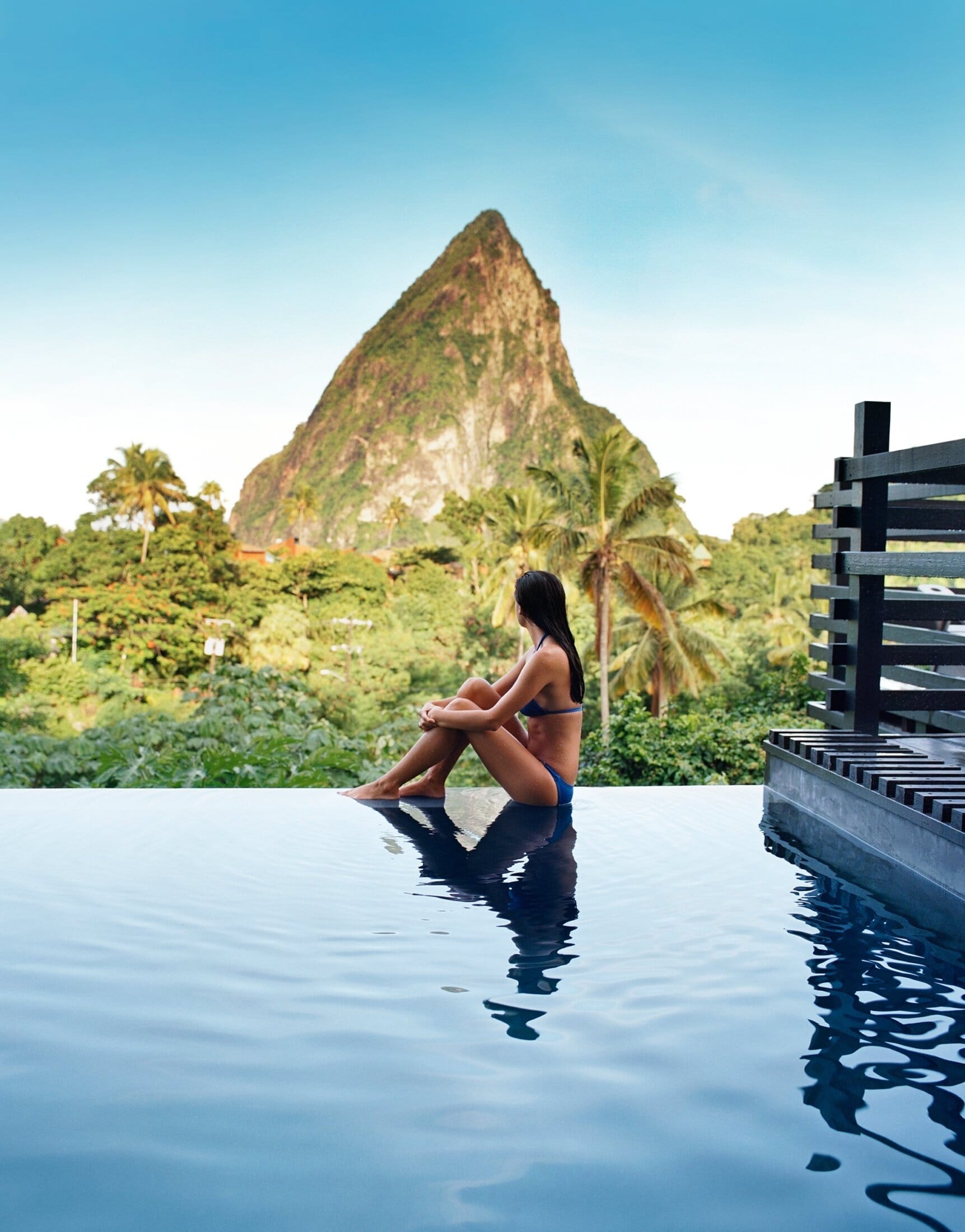 Woman sat by Rabot Hotel's Infinity pool, looking at Petit Piton